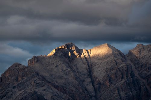 Free Sunlit mountain peaks under a dramatic sky in Cortina d'Ampezzo, Italy. Stock Photo
