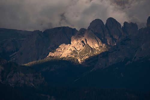 Free Moody mountain landscape with dramatic lighting and cloudy sky at sunset. Stock Photo