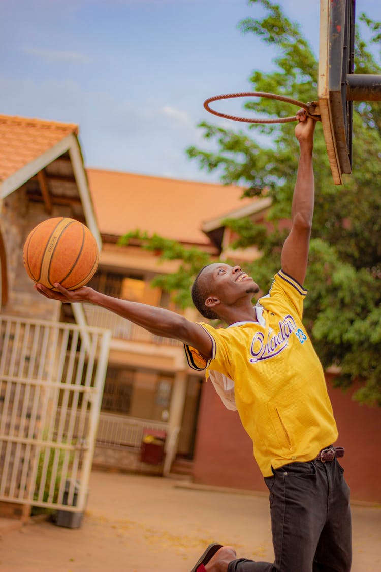 Man Playing Basketball In House Yard