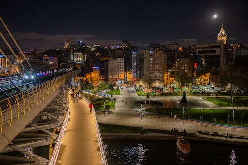 Illuminated Park and Galata Tower behind Halic Bridge at Night