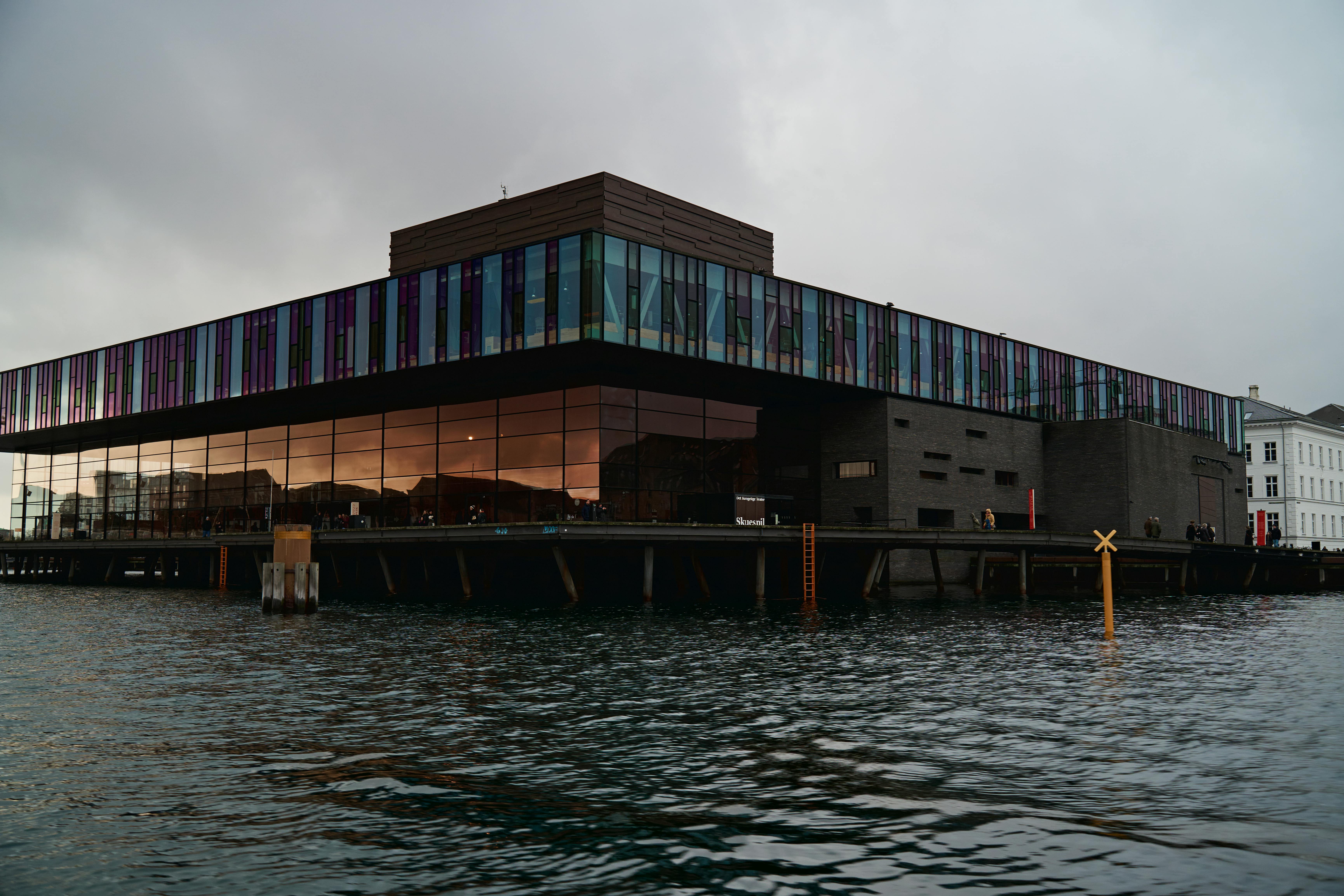Free The Royal Danish Playhouse in Copenhagen reflects beautifully on the canal at sunset. Stock Photo