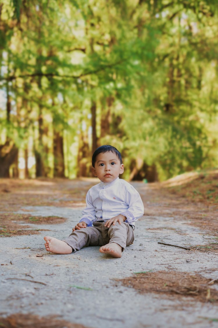 Boy In Shirt Sitting On Ground