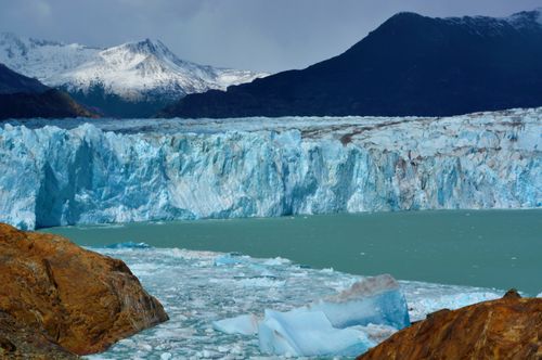 Free Breathtaking view of Perito Moreno Glacier with icy waters and mountain backdrop in El Chalten, Argentina. Stock Photo