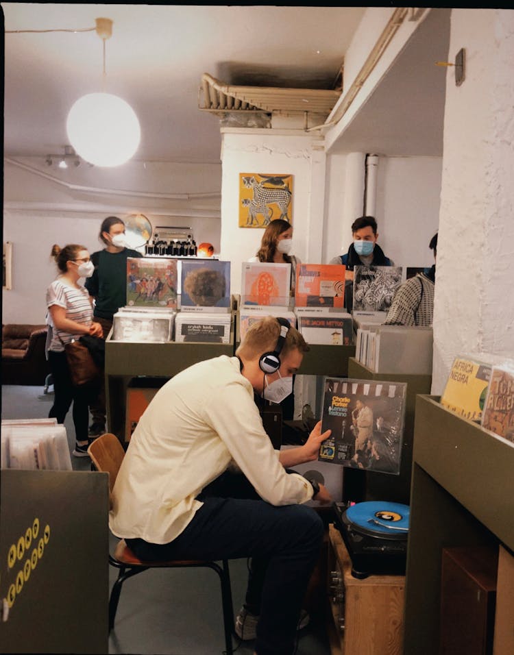 People In A Music Store Listen To The Vinyls