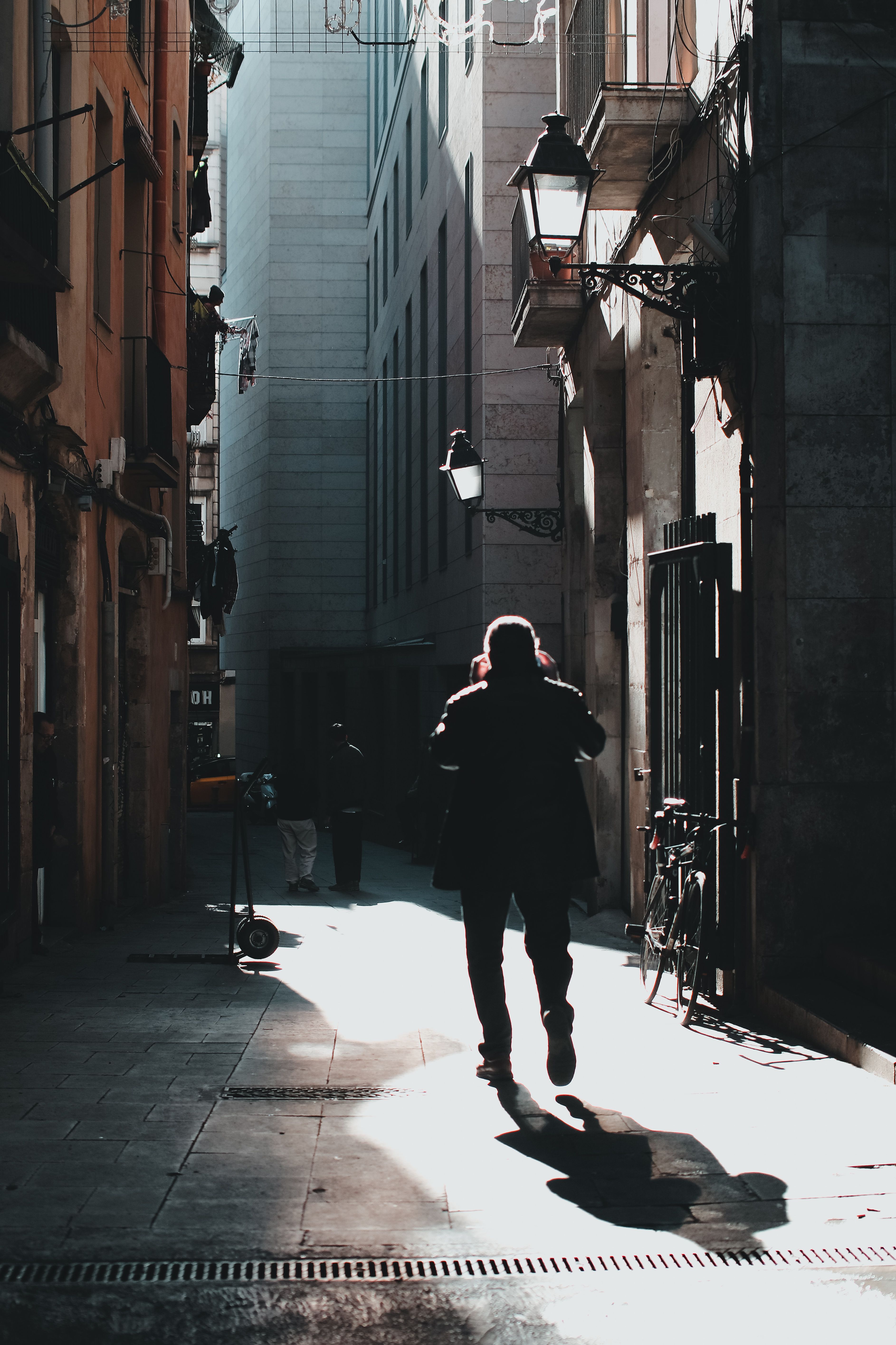 Silhouette of Man Walking through Bright Street · Free Stock Photo