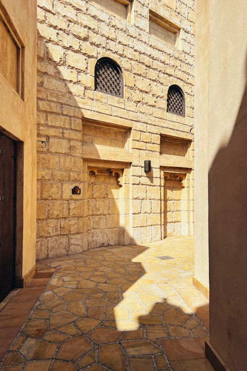 Free Explore a sunlit traditional stone alleyway in Dubai, showcasing rustic architecture. Stock Photo