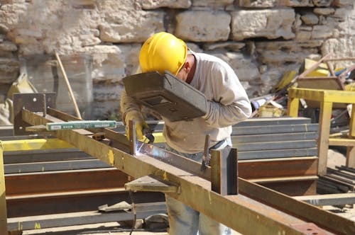 A man welding metal beams in a construction site