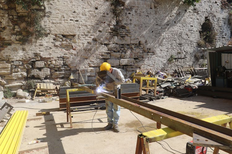 A Construction Worker Welding A Steel Bar