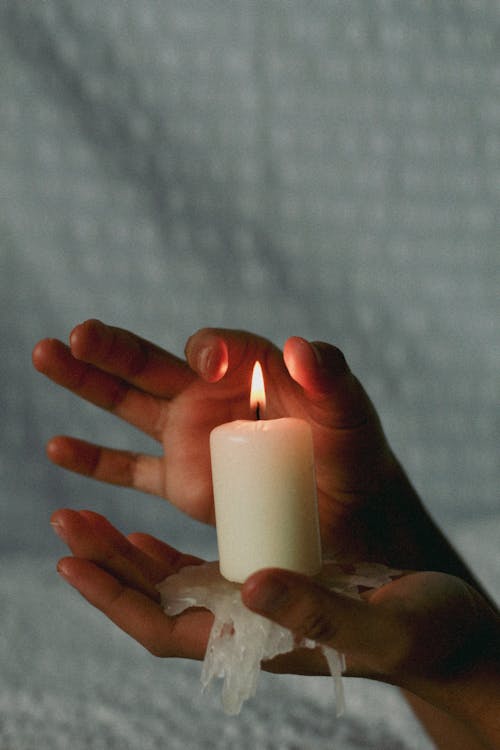 Hands Holding Melting Candle