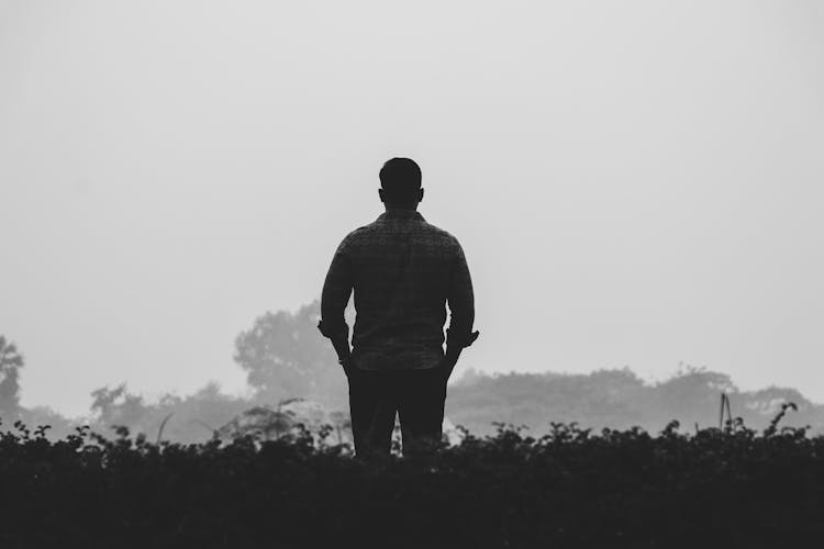 Back View Of An Alone Man In The Dark Environment 