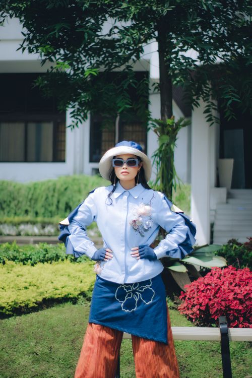 Free Fashionable woman posing in a vibrant garden in Bandung, Indonesia. Stock Photo