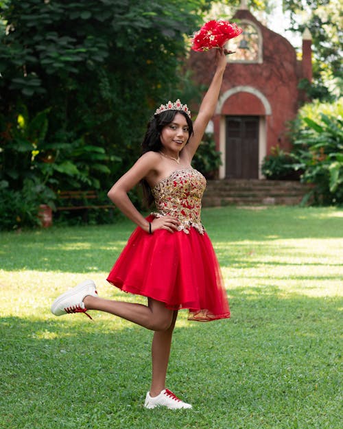 Brunette Woman in Red Skirt Standing with Flowers in Raised Arm