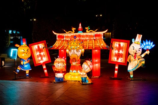 Colorful traditional lanterns illuminated at night, showcasing cultural artwork and festive decorations.
