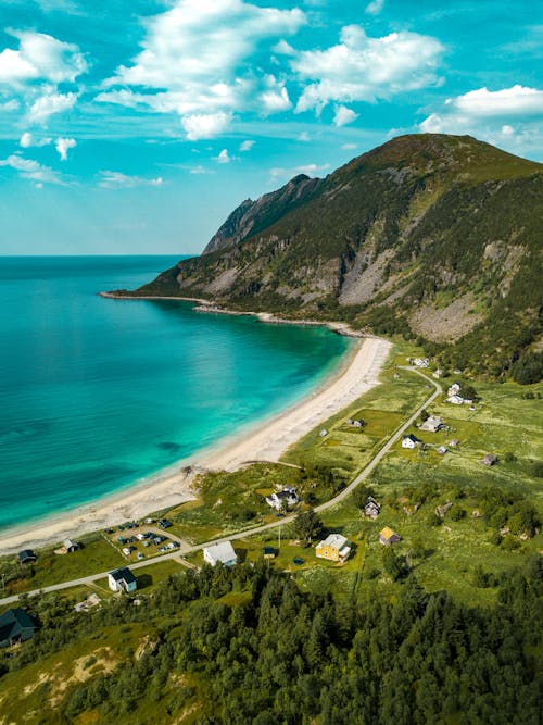 Aerial View of Shore Beside Green Mountains