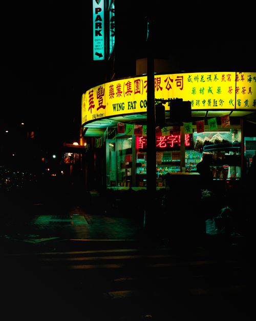 Free Vibrant nighttime street view of a neon-illuminated Asian grocery store corner. Stock Photo