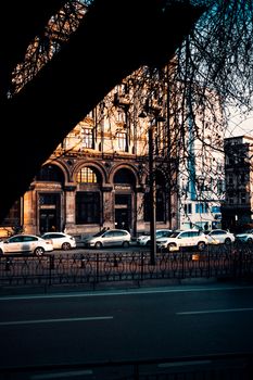 A vibrant street scene in Türkiye featuring historic architecture and parked cars under warm sunlight.