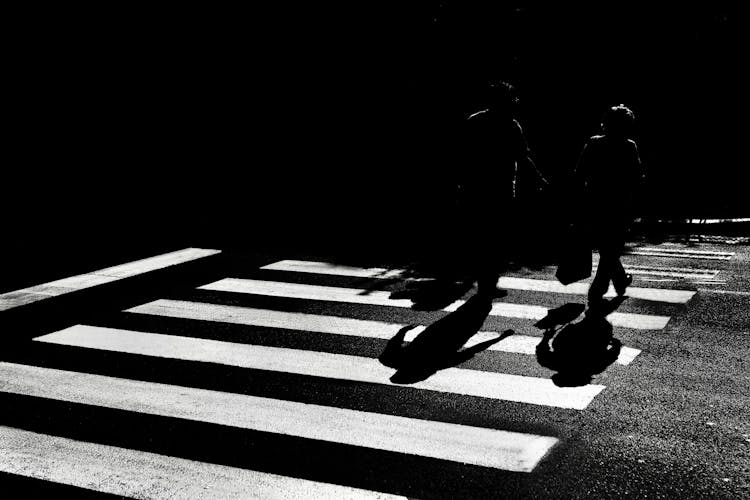 Silhouettes Of People Walking On Crossing