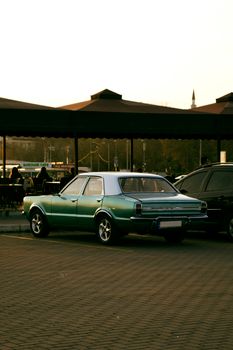 Classic green and white car parked at sunset in an urban İstanbul setting, Türkiye.