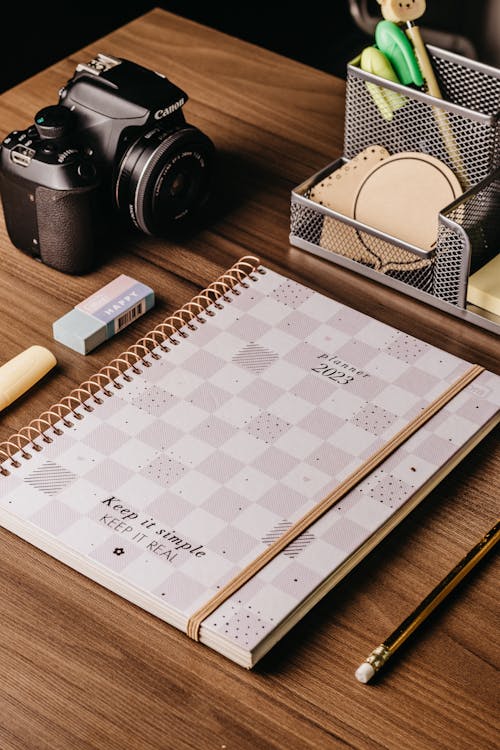 Free Planner, a Pencil, a Camera and Stationery on a Desk Stock Photo