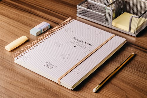 Free Paper Notebook on Wooden Desk Stock Photo