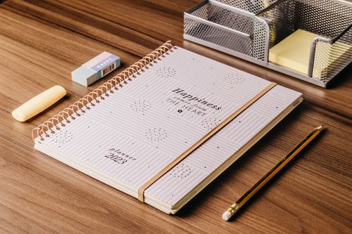 Free Minimalist 2023 planner with stationery on a wooden desk, perfect for organizational themes. Stock Photo