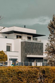 Contemporary house facade with geometric design elements and landscaping.