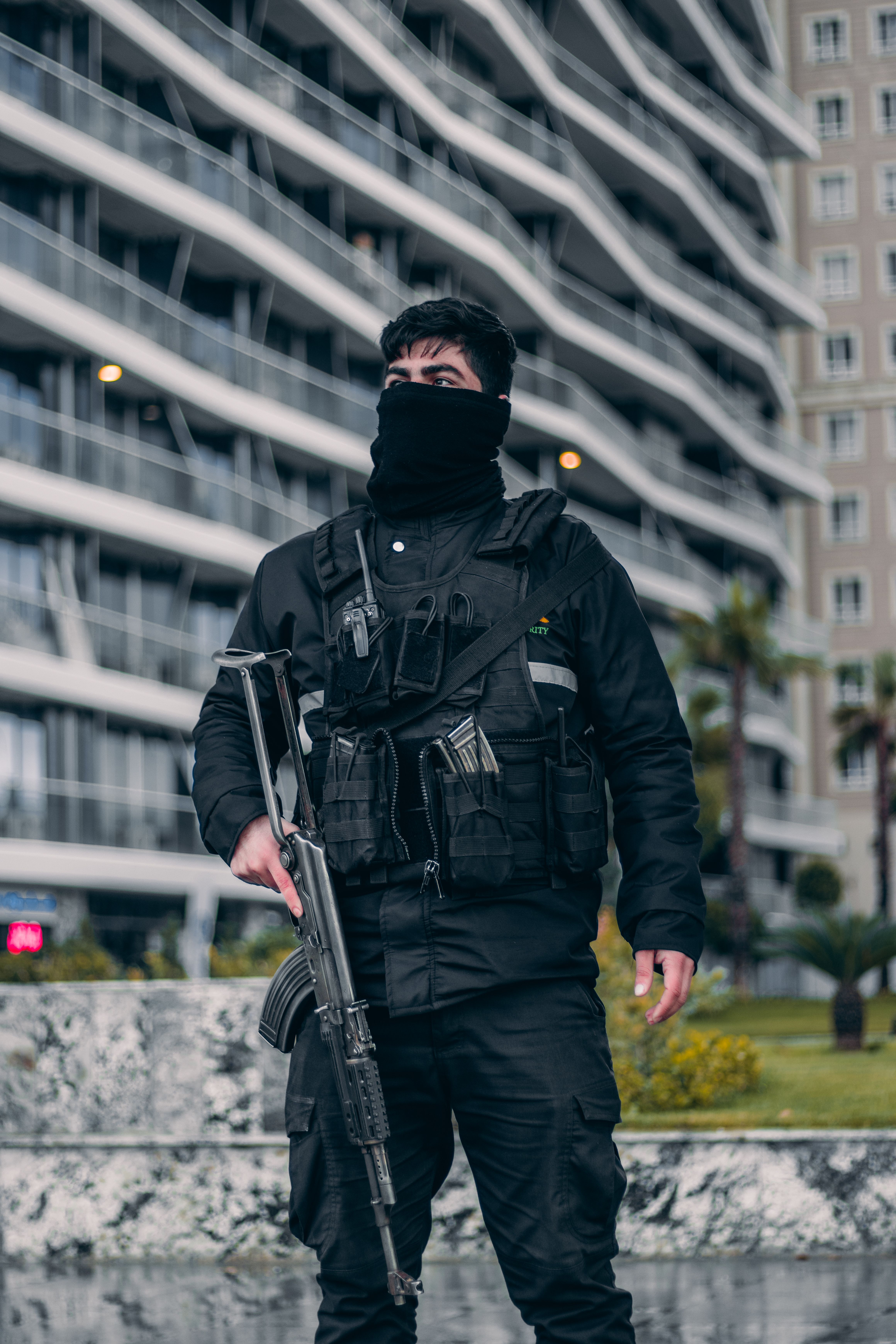 A soldier in tactical gear stands vigilant in an urban setting, showcasing readiness.