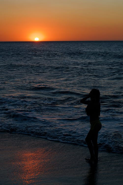 Silhouette of Woman by the Sea During Sunset 