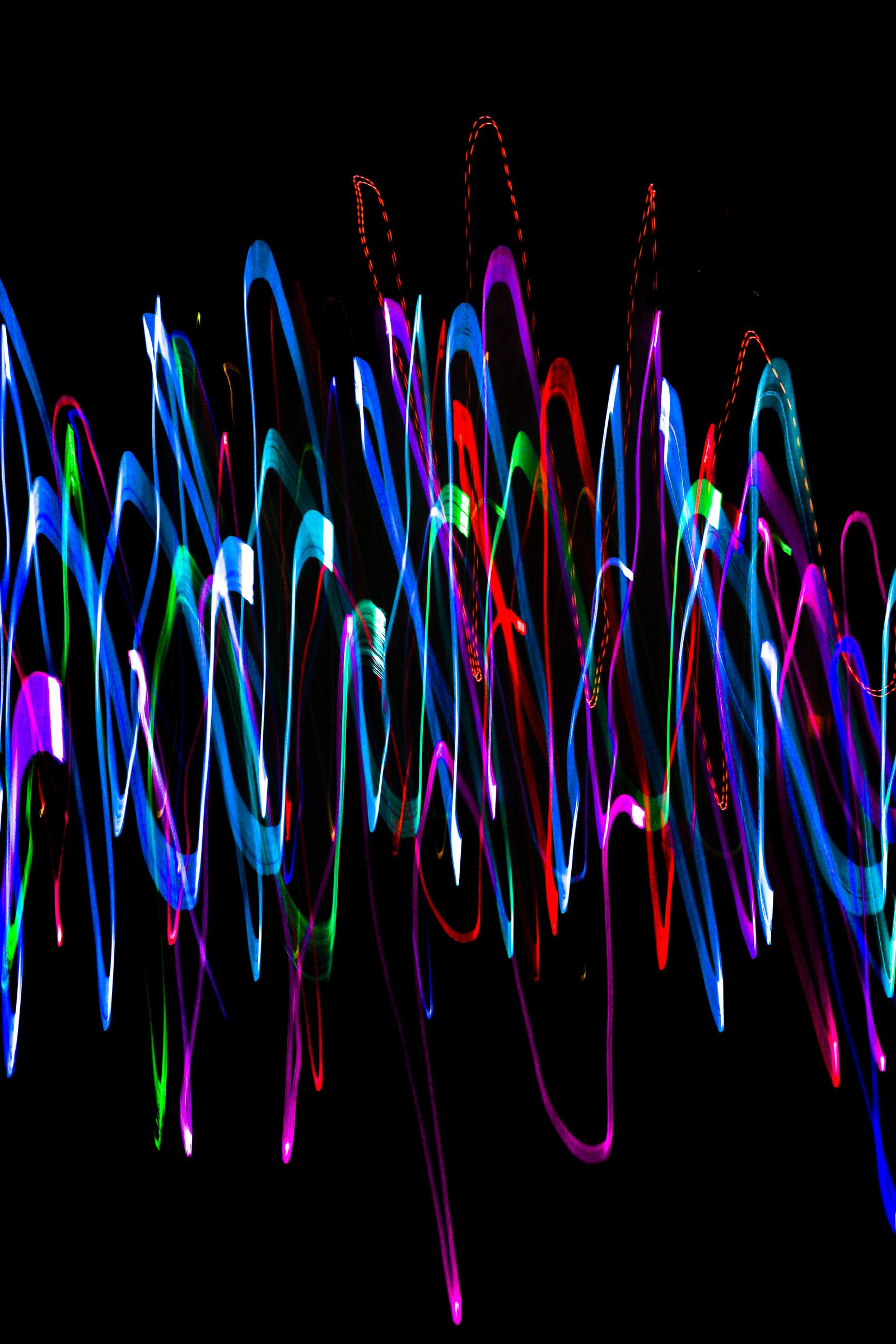 Overlapping neon sound waves on a black background