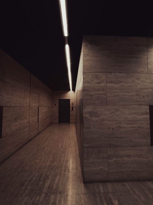 Free An empty, dimly lit modern corridor with marble walls and a sleek design. Stock Photo