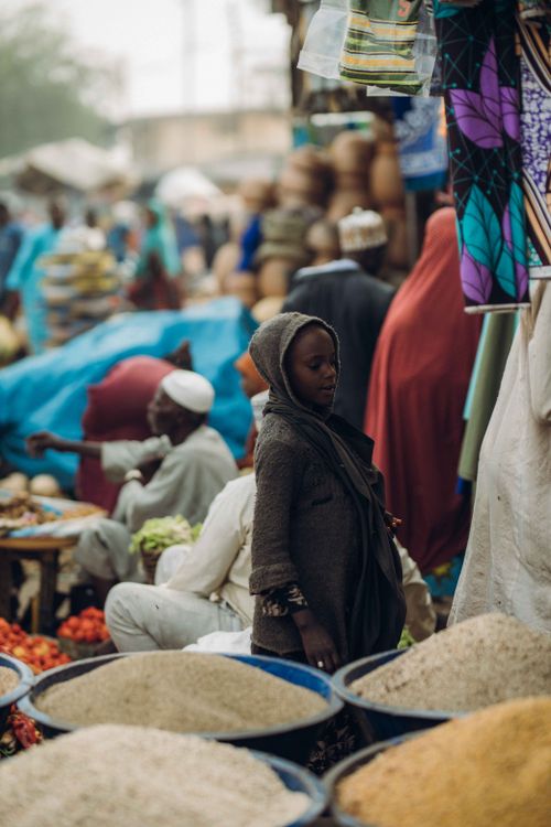 Free A bustling market scene with vendors and a woman in traditional attire amidst colorful goods. Stock Photo