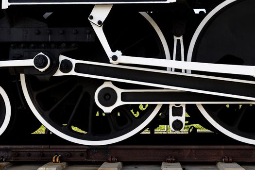 A detailed view of classic locomotive wheels and machinery, showcasing vintage engineering.