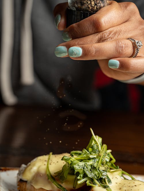 Woman Grinding Pepper on Meal