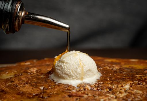 Close-up of a pancake topped with vanilla ice cream and honey drizzle, perfect for desserts.