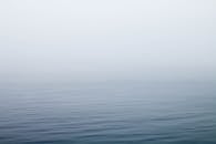 薄雾缭绕在平静的湖面上，水面泛起柔和的涟漪