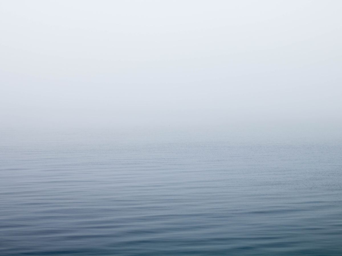A still lake under low morning fog