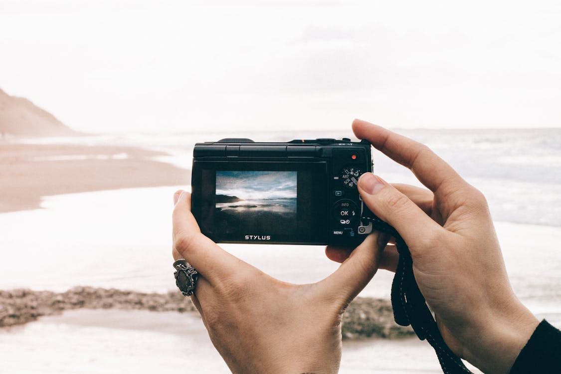 무료 Point And Shoot 카메라를 사용하여 바다 사진을 찍는 사람 스톡 사진
