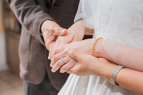 Man Hands Holding Woman Hands in Wedding Dress