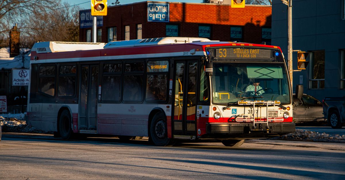 Um ônibus da TTC de Toronto numa rua no inverno sob luz brilhante do dia, mostrando o transporte urbano.