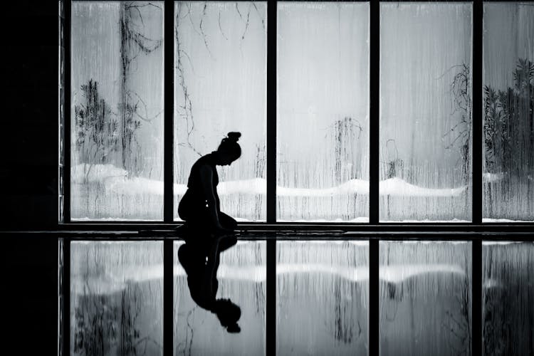 Silhouette Of A Woman Kneeling