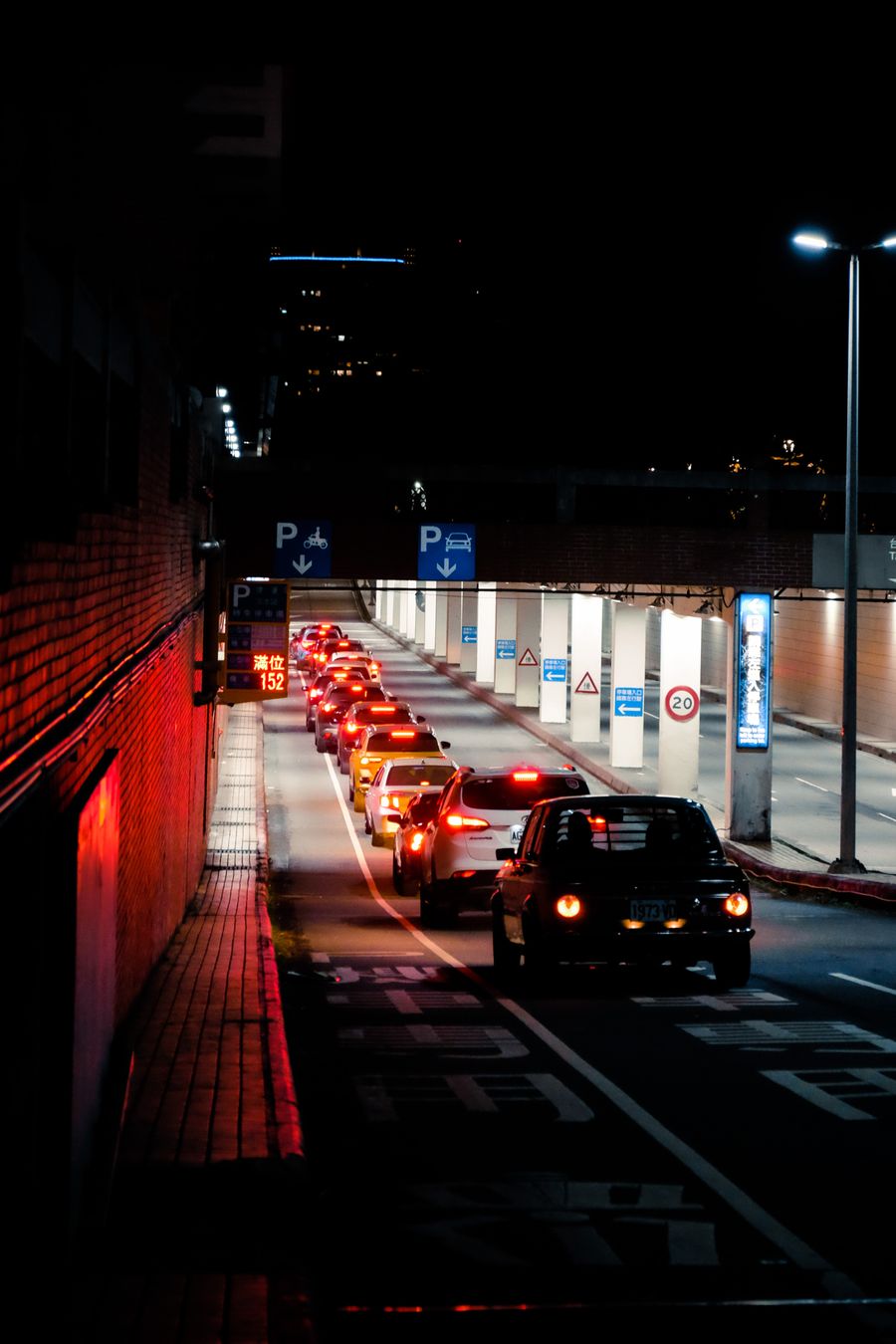 Line of vehicles entering a car park at night