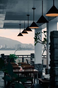 Elegant outdoor dining area overlooking the ocean at dusk, perfect for a serene evening.