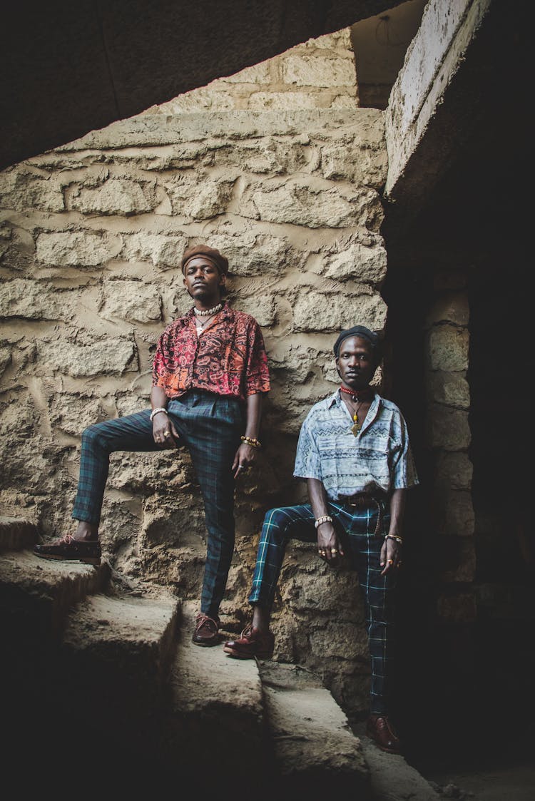 Stylish Men Standing On Stairs In Old Stone Building