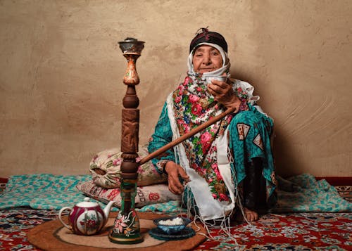 Elderly Iranian Woman with Hookah in Home