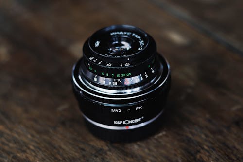 Close-up of a Camera Lens Lying on a Wooden Surface
