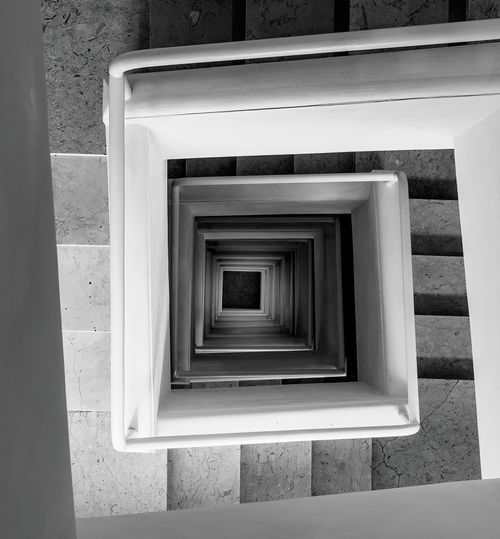 Free Top-down view of a spiral staircase in a modern building with a geometric aesthetic in Palermo, Italy. Stock Photo