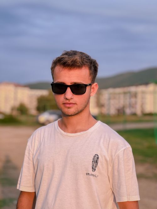 Free Stylish young man in a white t-shirt and sunglasses enjoying a sunny day in Çınarcık, Türkiye. Stock Photo