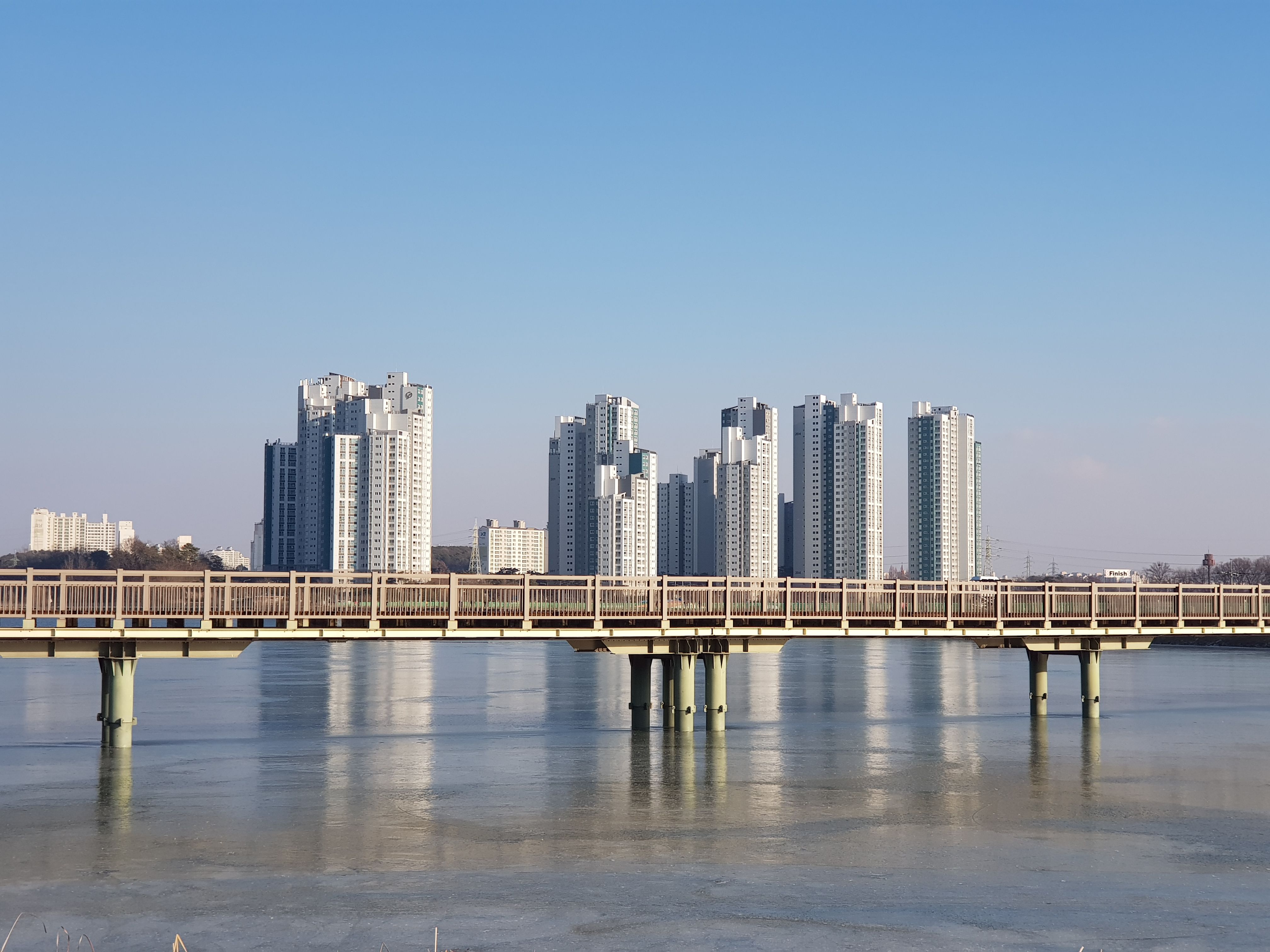 Modern high-rise buildings with a bridge reflection on a calm river in Uiwang, Gyeonggi Province.