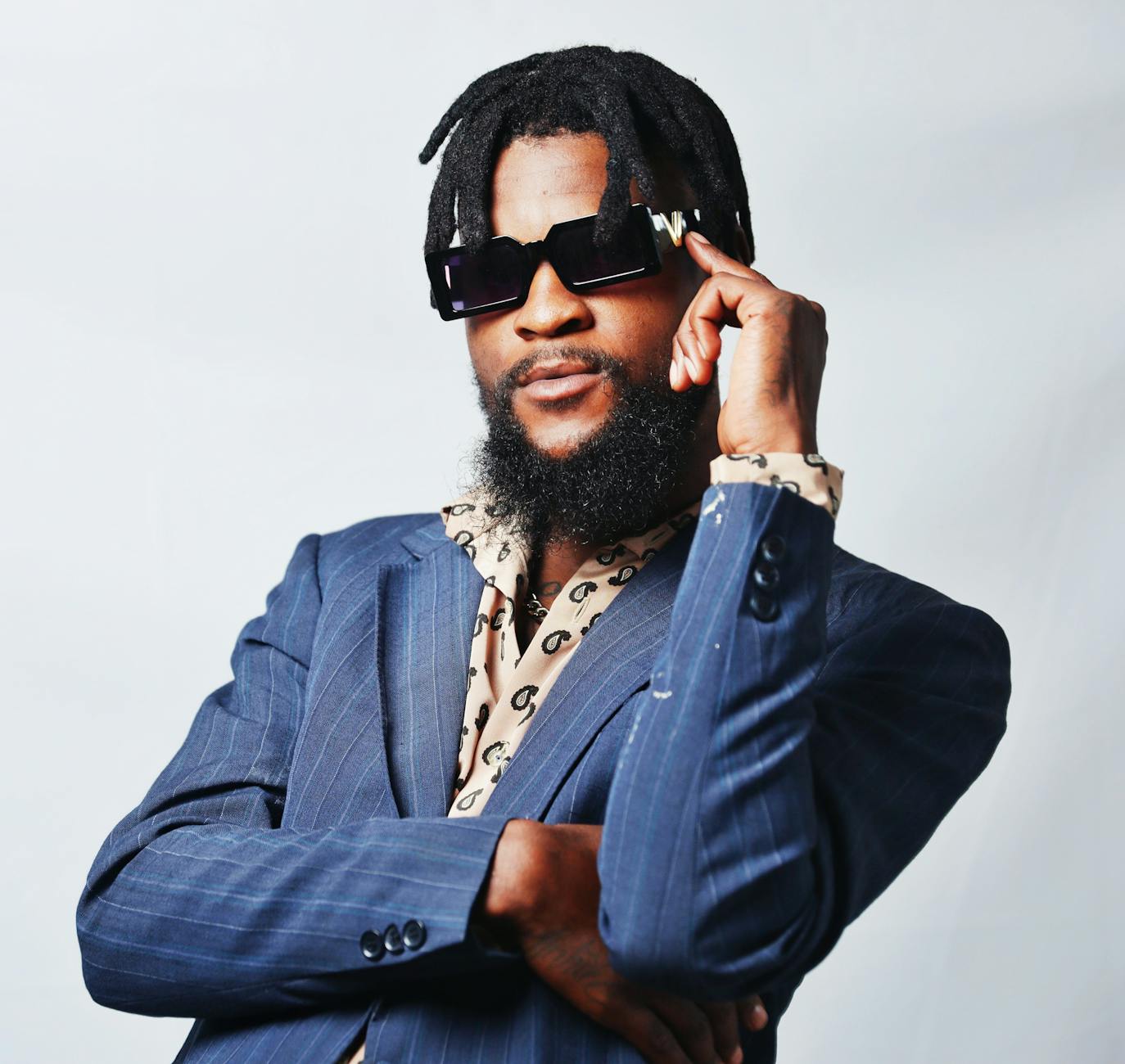 A man with a beard and sunglasses is posing for a photo