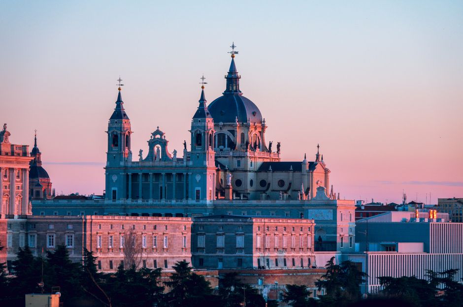 Impresionante vista del atardecer de la Catedral de Almudena en Madrid, España, con un vibrante fondo de skyline.